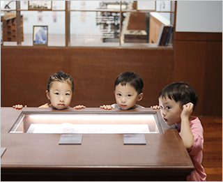 한글 잡지 『어린이』의 창간 100주년을 기념하여 국립한글박물관에서 열리고 있는 기획특별전 <어린이 나라> 현장 사진이다. 벽에 있는 전시장과 공간 한가운데 전시장, 바닥 모두 갈색으로 이루어져 있다.